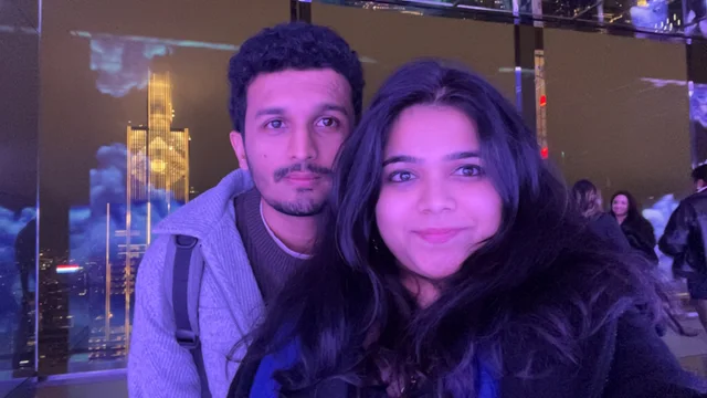 Akanksha and Kushal taking a selfie against the New York night skyline