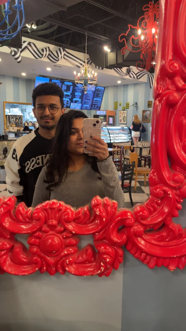 Akanksha and Kushal in a mirror selfie in a red frame